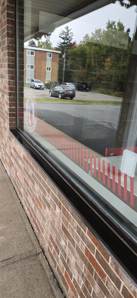 Large clean storefront window set in a brick wall